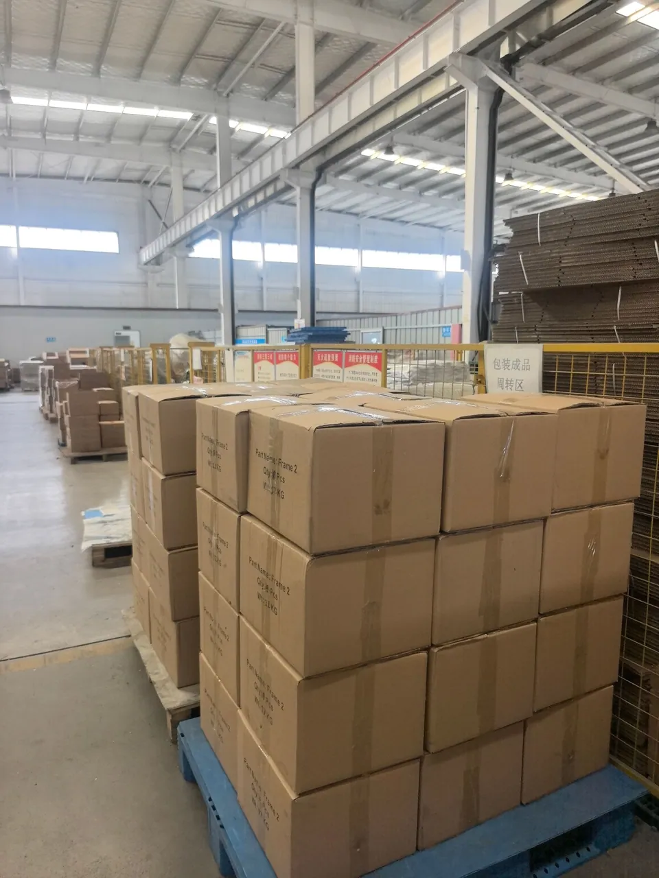 Cartons on a blue pallet in the marked packing transfer area