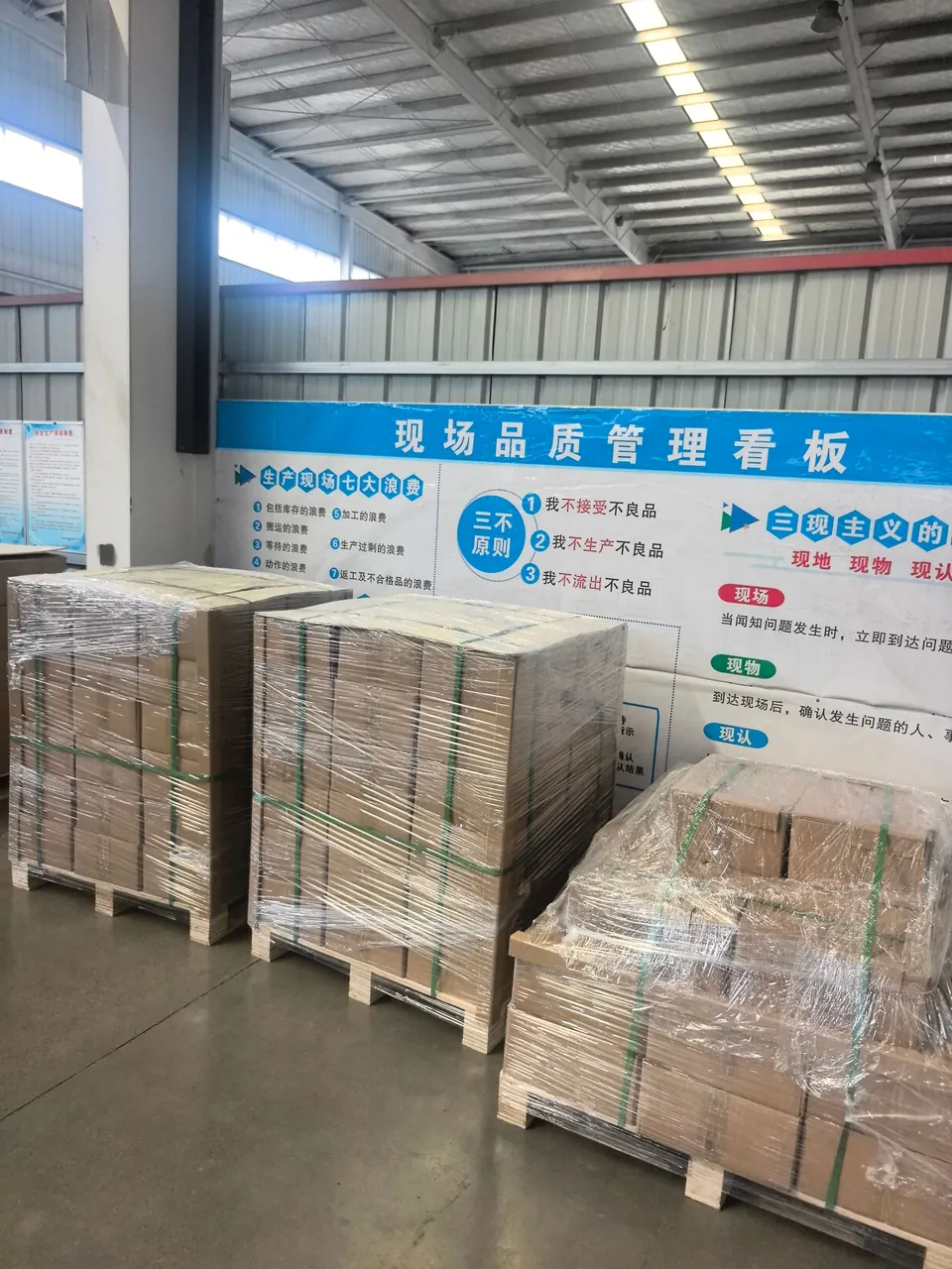 Cartons secured on pallets with wrapping film and green straps