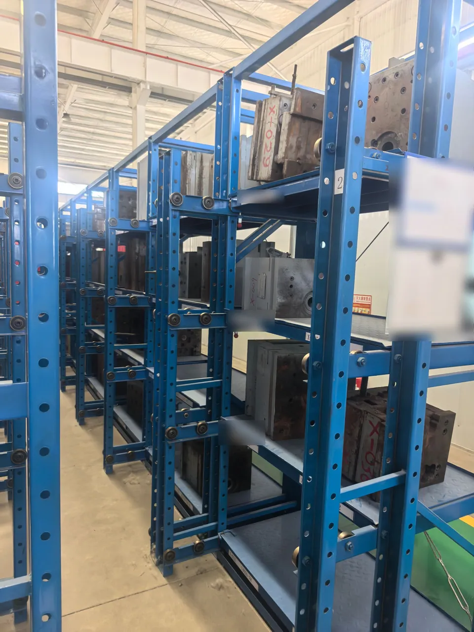 Metal tooling stored on blue pull-out racks with location labels